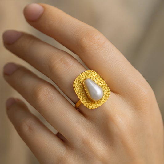 Adjustable gold brass pearl ring party wear showcased on a hand, featuring a textured gold finish and a teardrop pearl.