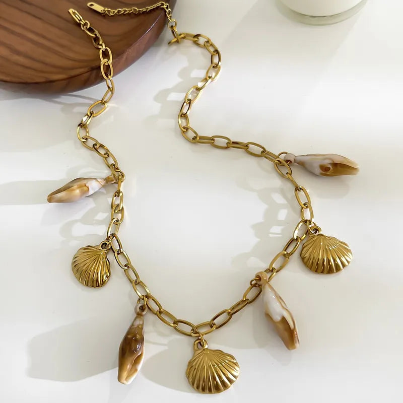 Elegant beach-style necklace with gold shell and conch charms.