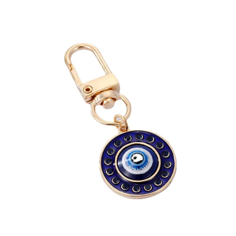 Keychain with blue evil eye design on a white background
