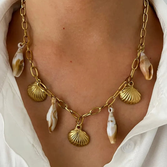 Gold chain necklace with natural seashell charms for a beach-inspired look.