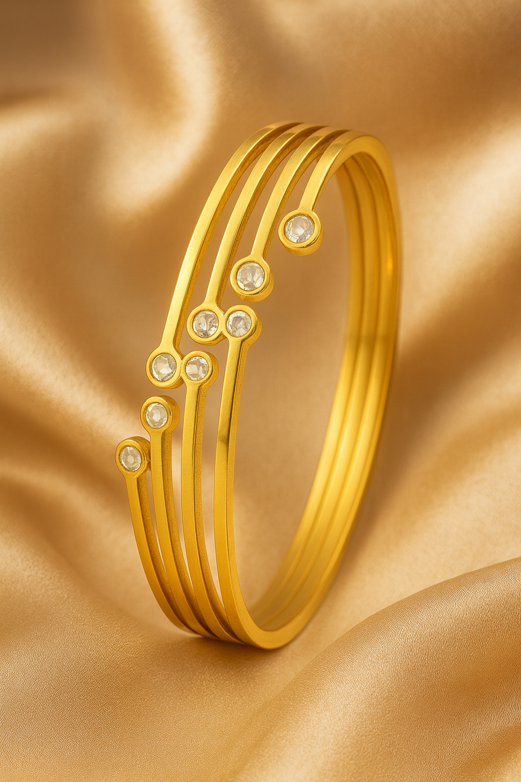 Gold bracelet with embedded stones on a gold fabric background